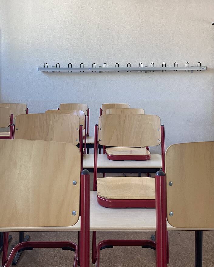 KLassenzimmer mit hochgestellten Stühlen